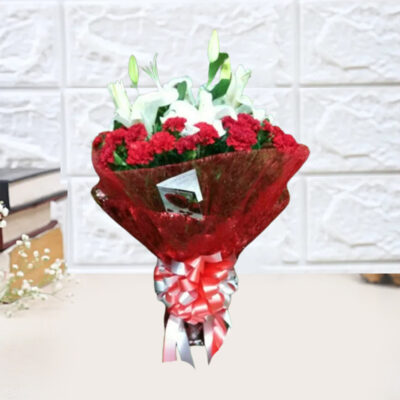 A stunning bouquet featuring 4 White Asiatic Lilies, 24 Red Carnations, wrapped in red non-woven paper, adorned with green Morpankhi leaf filler, and accented with red and white satin ribbon.