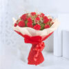 A charming bouquet comprising 20 red Roses, adorned with red and white non-woven packing sheets, tied with a red net ribbon bow, and accented with green and white fillers.