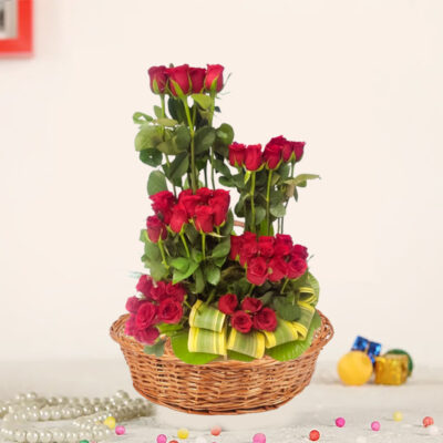 A luxurious arrangement comprising 40 Red Roses with China Palm and Dressina leaves fillers, presented in a rustic cane basket.