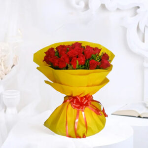 A stunning bouquet featuring 20 Red Roses accented with golden filler, wrapped in yellow packing paper, and adorned with a red ribbon bow