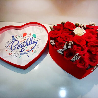 A romantic arrangement of 19 premium quality, unscented red roses, complemented by 1 white rose, all elegantly presented in a red heart-shaped box.