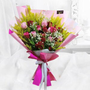 An elegant bouquet featuring 8 premium unscented Red Roses, 4 Light Pink Roses, and 4 Dark Pink Roses, adorned with golden green filler, elegantly tied with pink paper and a white ribbon.